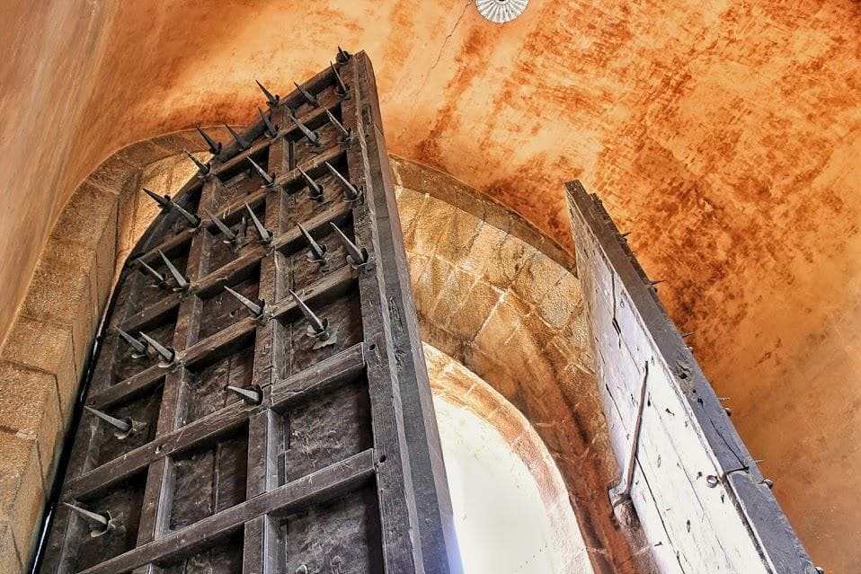 Iron defensive spikes fixed to the heavy wooden gate at Bengaluru Fort